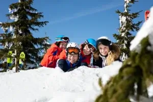 Familie der ligger på sne på skiferie i Tjekkiet
