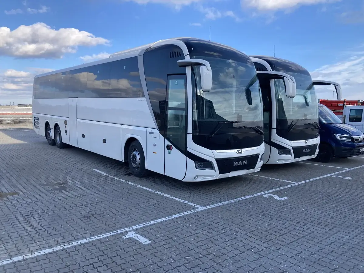To moderne MAN-turistbusser parkeret side om side, brugt på skirejser