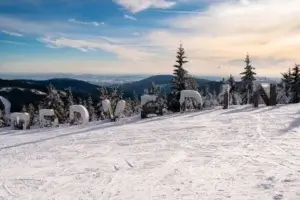 Pistenavn Medvedin i store bogstaver på toppen af Spindleruv Mlyn, med bjergpanorama i baggrunden